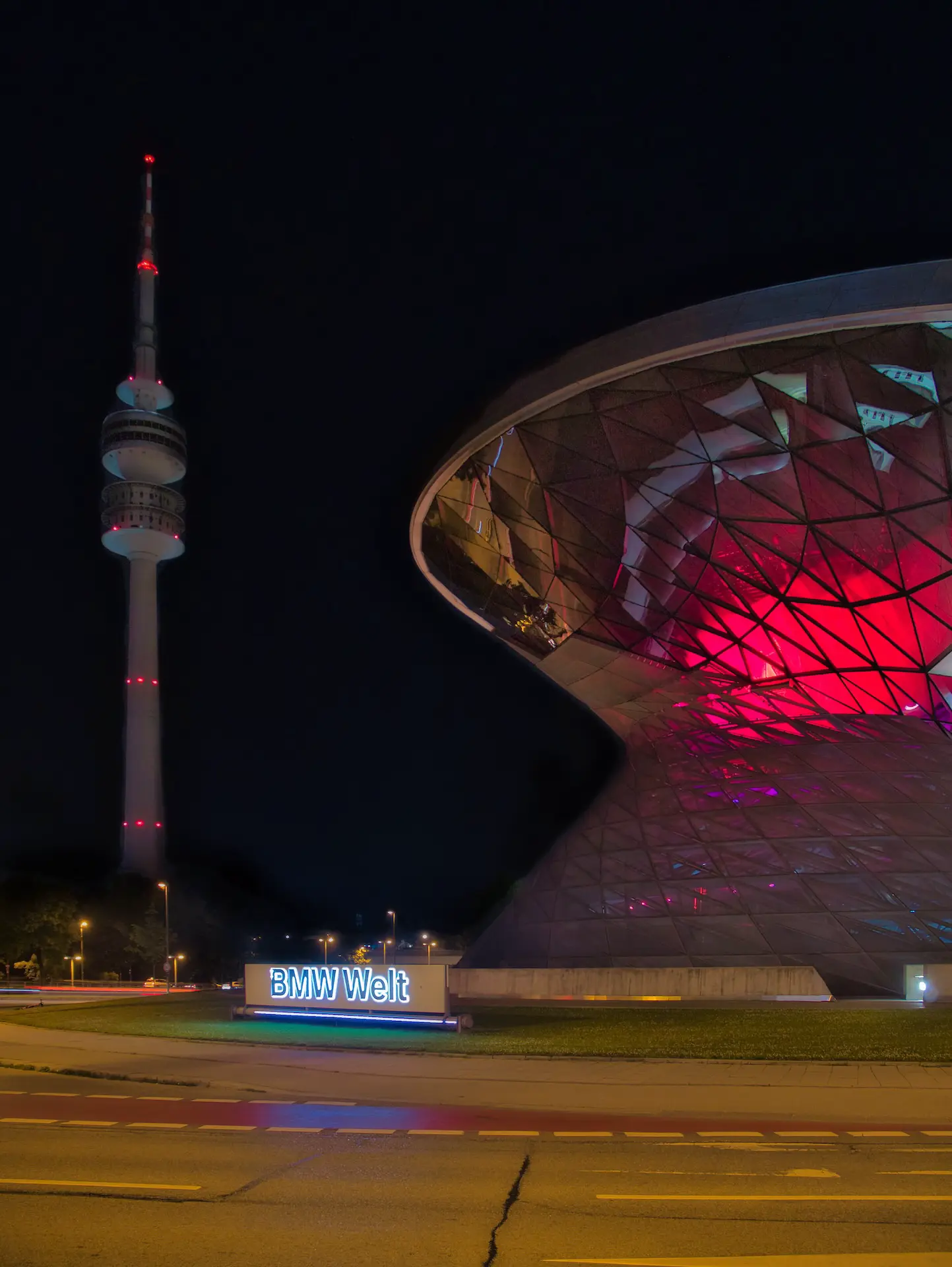 eleuchtete BMW Welt und Fernsehturm bei Nacht, steht für smarte Telekommunikation und Kostenoptimierung.